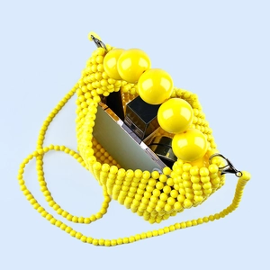 Macro view of yellow handmade beaded bag interior showing storage space for phone and makeup