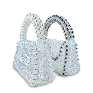 Détail de mini sacs perlés montrant l'artisanat du cristal et des perles blanches