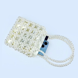 Detail of handmade pearl beaded handbag with satin lining showing internal phone storage capacity