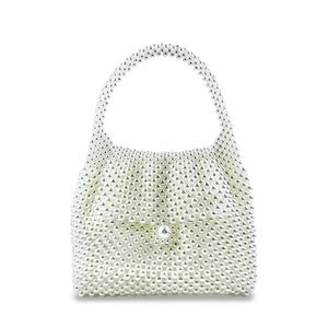 Detailed view of handmade white pearl beaded handbag with large decorative pearl closure