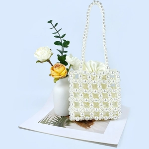 Detail of handmade pearl beaded handbag with cream satin drawstring lining and mesh design