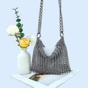 Detailed close-up of handmade gunmetal chainmail mesh texture on a metallic evening bag
