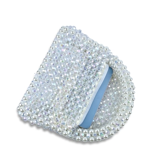 Détail du sac perlé montrant des perles blanches, cristaux arc-en-ciel et capacité interne