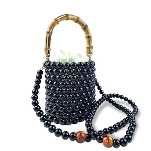 Detailansicht der schwarzen Perlen-Eimertasche mit Bambusgriff und goldenen Beschlägen
