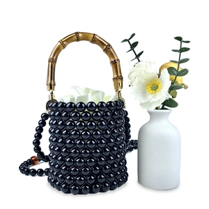Detail der Perlen-Eimertasche mit Bambusgriff und elegantem weißem Satin-Innenfutter
