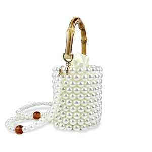 Detail einer handgefertigten Perlen-Beuteltasche mit Bambusgriff und Satin-Innenbeutel