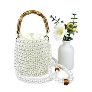 Detail der Perlen-Eimertasche mit Bambusgriff und gelbem Satin-Innenfutter aus Seide