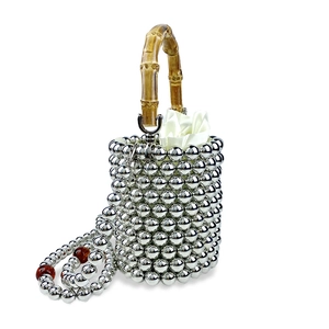 Detail der silbernen Perlen-Eimertasche mit Bambusgriff und Satin-Innenfutter mit Kordelzug