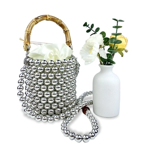 Details der silbernen Perlen-Eimertasche mit Bambusgriff, Satinfutter und Perlenkette