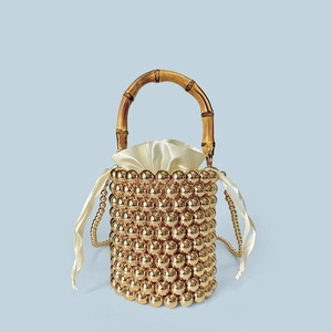 Detail der goldenen Perlen-Eimertasche mit Bambusgriff und Satin-Innenbeutel für Damen
