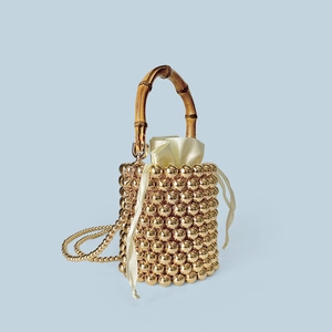 Detail der goldfarbenen Perlen-Beuteltasche mit Bambusgriff und Satin-Innentasche