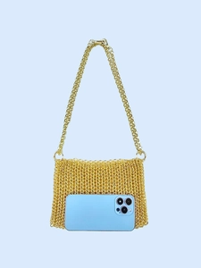 Gold metal mesh handmade woven crossbody bag with chain strap holding a large smartphone