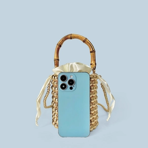 Mini-Perlen-Beuteltasche in Gold mit Bambusgriff und Handy zum Größenvergleich