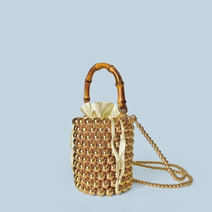 Detail der goldenen Perlen-Beuteltasche mit Bambusgriff und Satin-Innenbeutel mit Kordelzug