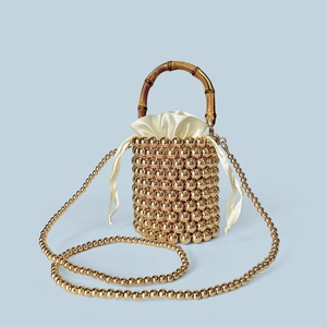 Detail der goldenen Perlen-Beuteltasche mit Bambusgriff und Satin-Innenbeutel