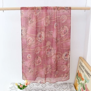 Detail view of semi-transparent scarf with vintage floral patterns and gold stamping details