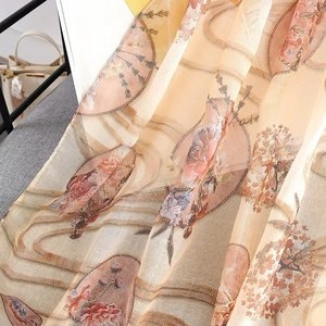Detail of orange chiffon scarf with gold floral prints and traditional folding fans