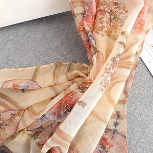 Close-up of translucent floral scarf with elegant gold foil threads and soft texture