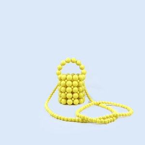 Mini bolso de mano artesanal con cuentas amarillas y asa redonda de perlas
