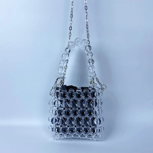 Détail du mini sac perlé avec perles transparentes, doublure noire et chaîne en métal