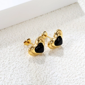 Close-up of vintage gold heart stud earrings with black center and butterfly back