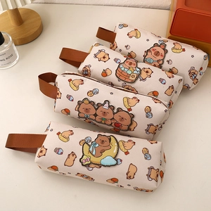 Dettaglio di quattro astucci in tela beige con stampe di capibara e manici laterali