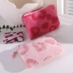 Pink plush heart makeup bag with fleece texture and zipper closure for travel
