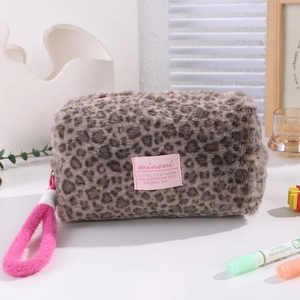 Macro shot of fluffy leopard print plush cosmetic bag with pink brand label and lanyard