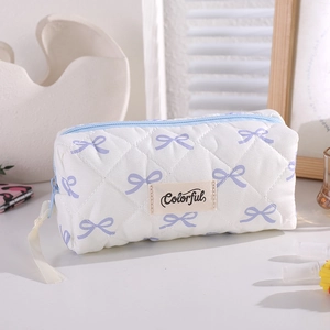 Close-up of quilted pencil case with purple bow pattern and blue zipper detail