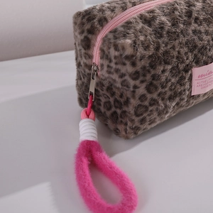 Leopard print plush makeup bag with pink zipper and fluffy strap on white background