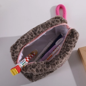 Macro view of leopard print plush makeup bag showing soft texture and pink zipper detail