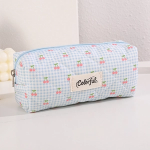 Detail shot of blue gingham quilted pencil case with cherry print and Colorful woven label