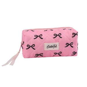 Pink quilted pencil case with black bow patterns and zipper closure for stationary storage