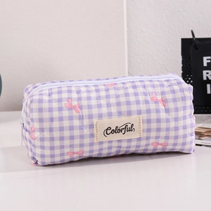 Dettaglio della borsa per il trucco trapuntata a quadri viola con stampe di fiocchi rosa