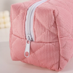 Detailansicht der rosa Cord-Steppstoffstruktur und des hochwertigen weißen Reißverschlusses