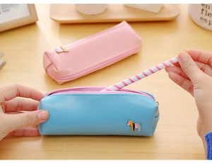 Macro detail of PU leather pencil cases with colorful metal horse charms and zipper closure
