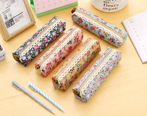 Detailed close-up of floral canvas pencil cases with lace trim and gold zippers