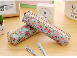 Detail of floral and polka dot canvas pencil cases with elegant white lace zipper trim