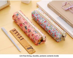 Floral canvas pencil bags with white lace trim and vintage zippers on wooden desk