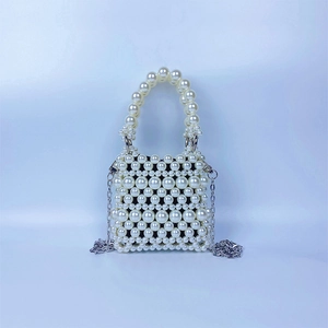 Détail du sac à main en perles tressées avec chaînes argentées et doublure noire