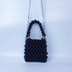 Vue détaillée du mini sac perlé noir tissé main avec bandoulière chaîne argentée et anse
