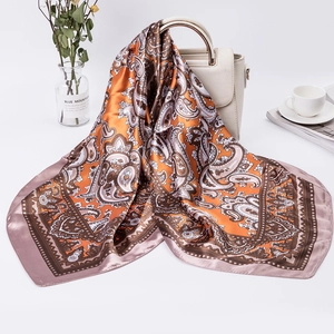 Elegant 90cm paisley print satin scarf draped over a beige leather bag for autumn fashion