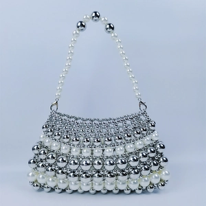 Détail de tissage de perles argentées et nacrées sur un sac baguette rétro français