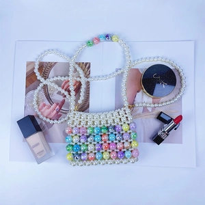 Gros plan d'un mini sac à perles fait main avec des perles colorées sur un magazine