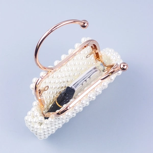Detail view of mini pearl evening bag showing interior capacity with a smartphone