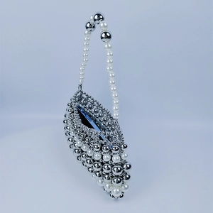 Détail d'un sac à main en perles fait main avec perles miroir argentées et espace téléphone