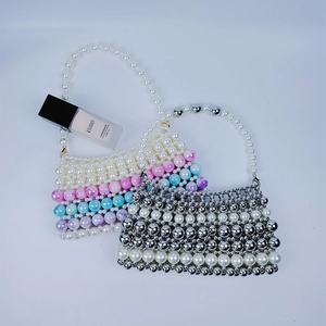 Détail de sacs à main artisanaux avec perles irisées et perles métalliques argentées