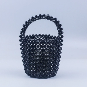 Détail d'un sac seau en perles noires fait main montrant des perles polies et une anse rigide