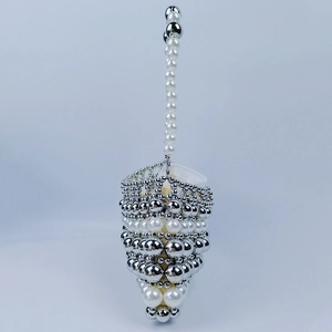 Détails des perles argentées et fausses perles sur un sac à main tissé main vintage