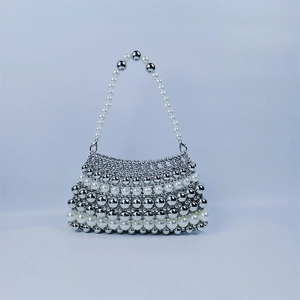 Détails de perles argentées et blanches tissées sur un sac à main vintage chic